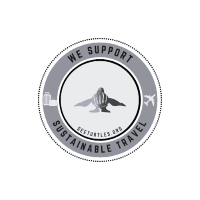 A circular gray logo featuring a silhouetted sea turtle in the center with the text "BESTTURTLES.ORG" below. Around the turtle, the outer ring reads "WE SUPPORT SUSTAINABLE TRAVEL" with icons of a suitcase and an airplane on either side, emphasizing eco-friendly adventures.